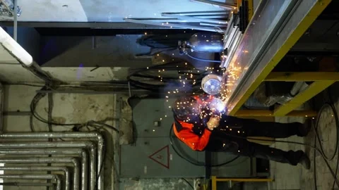 A man in a protective uniform and mask welds metal in a workshop. Stock Footage 321702805