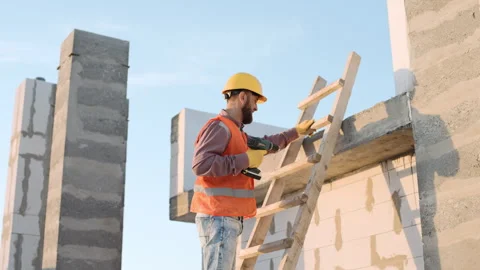 Man in a protective vest working on a construction site with a drill Stock Footage 303230219