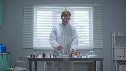 Man in protective workwear pour liquid into tube in the laboratory Stock Footage 123679489