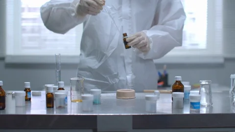 Man in protective workwear set fire to thing on table in the laboratory, slow Stock Footage 123663583