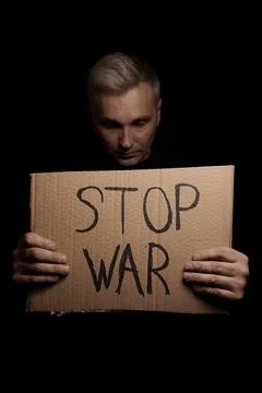 Man protesting with poster Stop War. Concept of armed conflict in Ukraine 스톡 사진