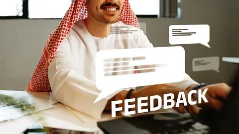 Man providing feedback in an office setting with chat bubbles displayed nearby Stock Photos