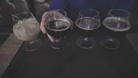 Man in a pub quickly drinks four glasses of spirits. Concept of games alcohol Stock Footage 151872592