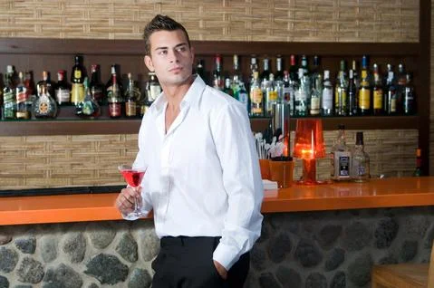 Man in a pub with red martini Stock Photos