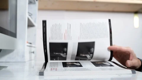 Man puff book on the desk. Computer on the background Stock Footage 98457789