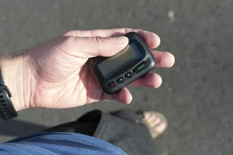 Man pulled out pager with a display from his pocket on the street 스톡 사진