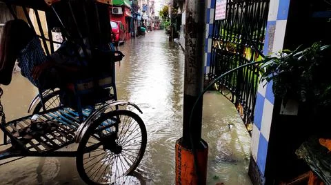 A man pulled rickshaw stands on the stage water in a street of Kolkata, India. 写真素材