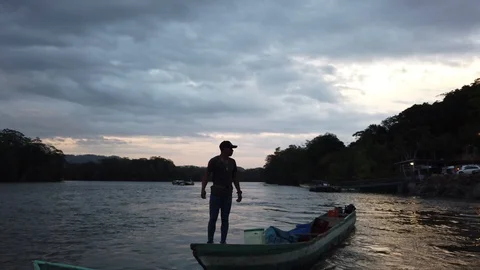 Man pulling canoe with a rope towards a pier on the river Stock Footage 111611277