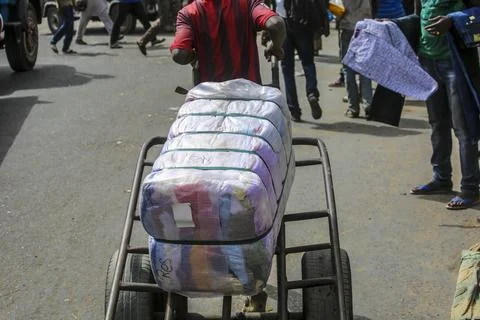 Man pulling clothes cart Stock Photos