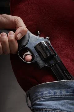 Man pulling a concealed .41 Magnum pistol from his waistband Stock Photos