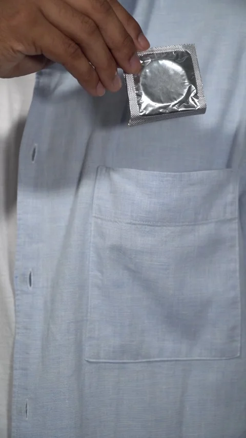 Man pulling condom from shirt pocket Stock Footage 314384563