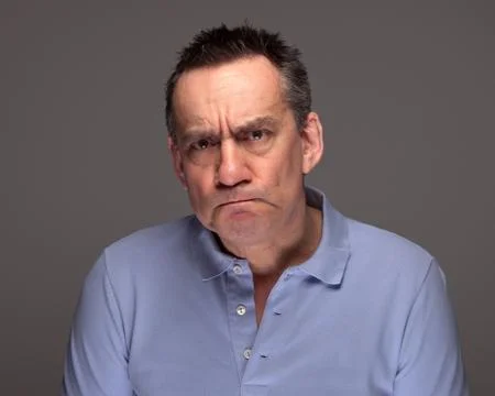 Man pulling grimace face and glaring Stock Photos
