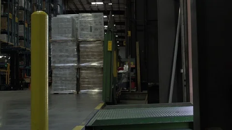 Man pulling hand operated pallet truck by entrance to warehouse. Stock Footage 88028134