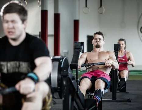 Man Pulling Handle Of Rowing Machine In Gym 写真素材