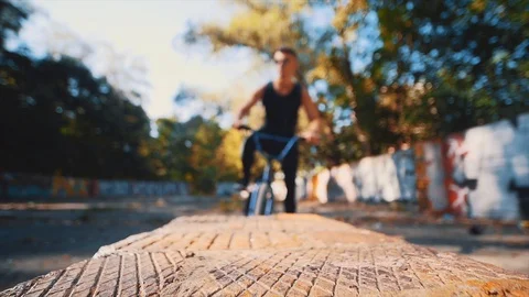 Man is pulling his BMX bike up. Close up wheel. Lower blurred view. 4K. Video stock 128315536