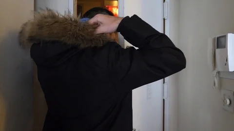 Man pulling hood over head &amp; walking out the door Stock Footage 114016017