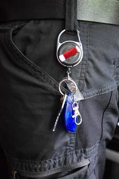 Man pulling a key on an extendable steel cord Stock-Fotos