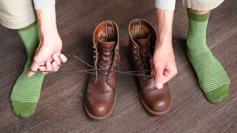 Man pulling laces from brown vintage boots Stock Footage 234096355