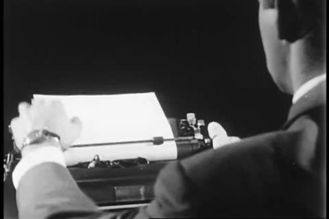 Man pulling up letter in typewritter in order to read it Видео 25061524