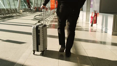 Man pulling luggage suitcase in the empty airport terminal. Stock Footage 154578537