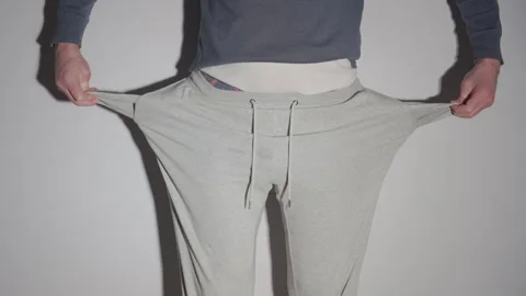 Man Pulling Out Empty Pockets of Gray Sweatpants | No Money, Financial Problem Stock Footage 330756638