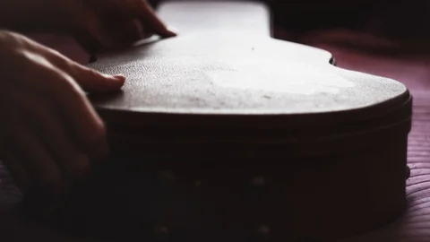 Man pulling out a guitar out of case. Closeup Stock Footage 104395886