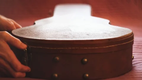 Man pulling out a guitar out of case and putting back. Closeup Stock Footage 104396354