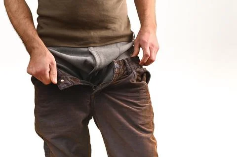 Man pulling pants over thermal leggings, adjusting for warmth and comfort. Stock Photos