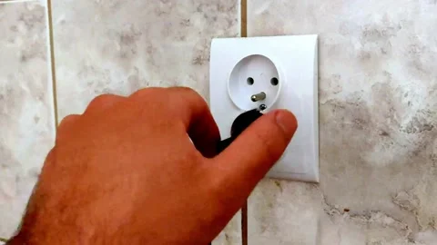 The man is pulling the plug from the socket. Unplug the power cord from the powe Stock Footage 156633210