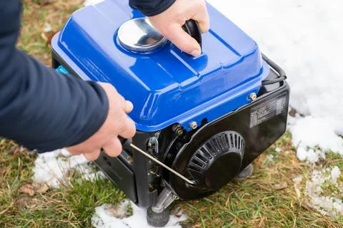Man pulling rope starter of an electric generator Stock Photos