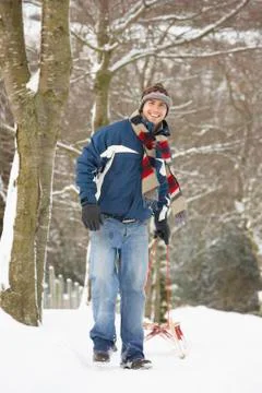 Man pulling sledge through winter landscape Stock Photos