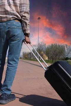 A man is pulling a suitcase with a handle. Holiday Conspet. Summer Time Stock Photos