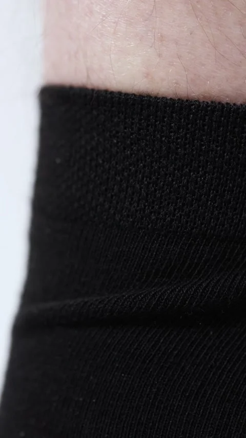 A man pulls and adjusts the elastic band on black socks Vídeos de archivo 265594014