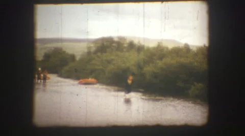 A man pulls a boat along the river. Vintage 8 mm. Video stock 51319385