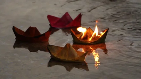 A man pulls a burning paper ship from other ships Stock Footage 94332867