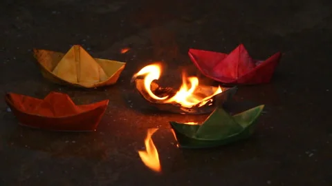 A man pulls a burning paper ship from other ships Stock Footage 106991735