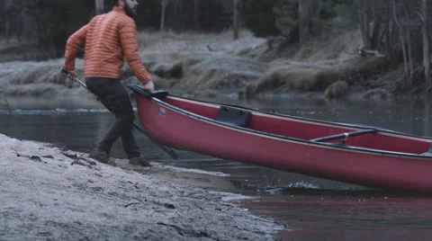 Man pulls canoe out of the Merced river in Yosemite Valley Stock Footage 59133262