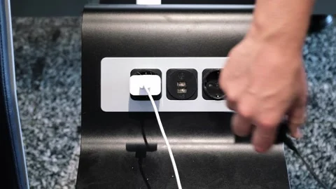 A man pulls the charger plug out of the socket in a public place. Electrical Stock Footage 307067651