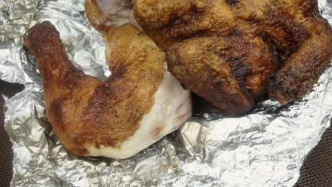 A man pulls a chicken leg out of a baked chicken. Close-up Vídeos de archivo 145628022