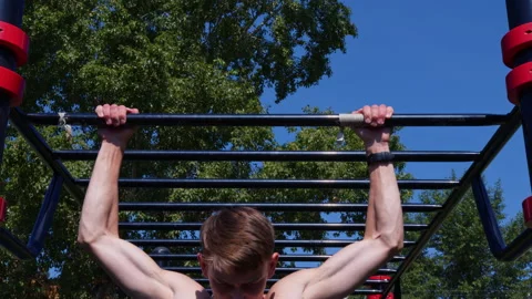 A man pulls up on the crossbar outdoors Video stock 201524717