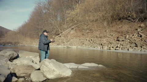 Man pulls fish out of the water.  Male fisherman fishing at the suny day. Outdoo Видео 133208184