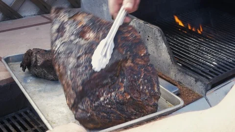 Man Pulls Flame Grilled Beef off a Barbecue Grill Stock Footage 104164057
