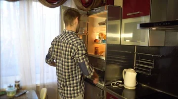 A man pulls food out of the refrigerator Stock-Footage 86156543