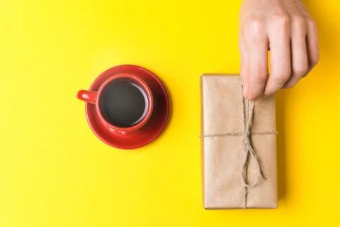 The man pulls a gift to yourself. Still life on yellow background Stock Photos