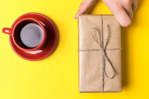The man pulls a gift to yourself. Still life on yellow background Stock Photos