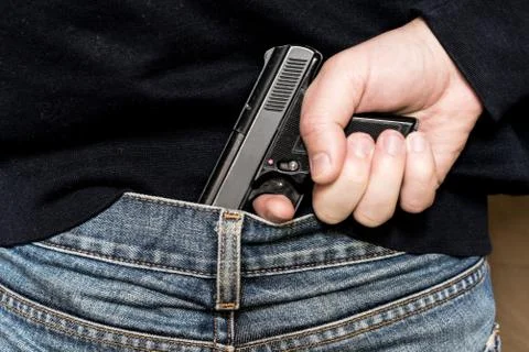 A man pulls a gun from behind Stock Photos