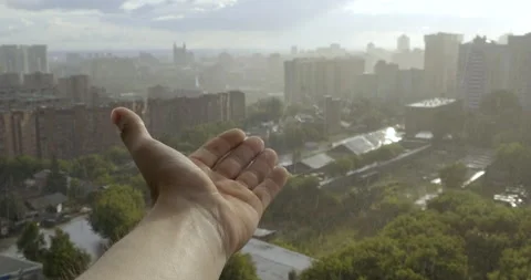 Man Pulls Hand from Balcony of Apartment and Catches Raindrops in Palm of Hand Stock Footage 134333289