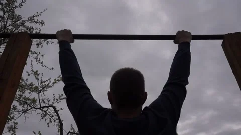 A man pulls himself up on a horizontal bar. Stock Footage 130593181