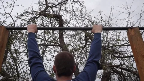 A man pulls himself up on a horizontal bar. Stock Footage 130594137