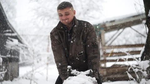 Man pulls on his old motorcycle for restoration. Snow falls Stock Footage 114630949